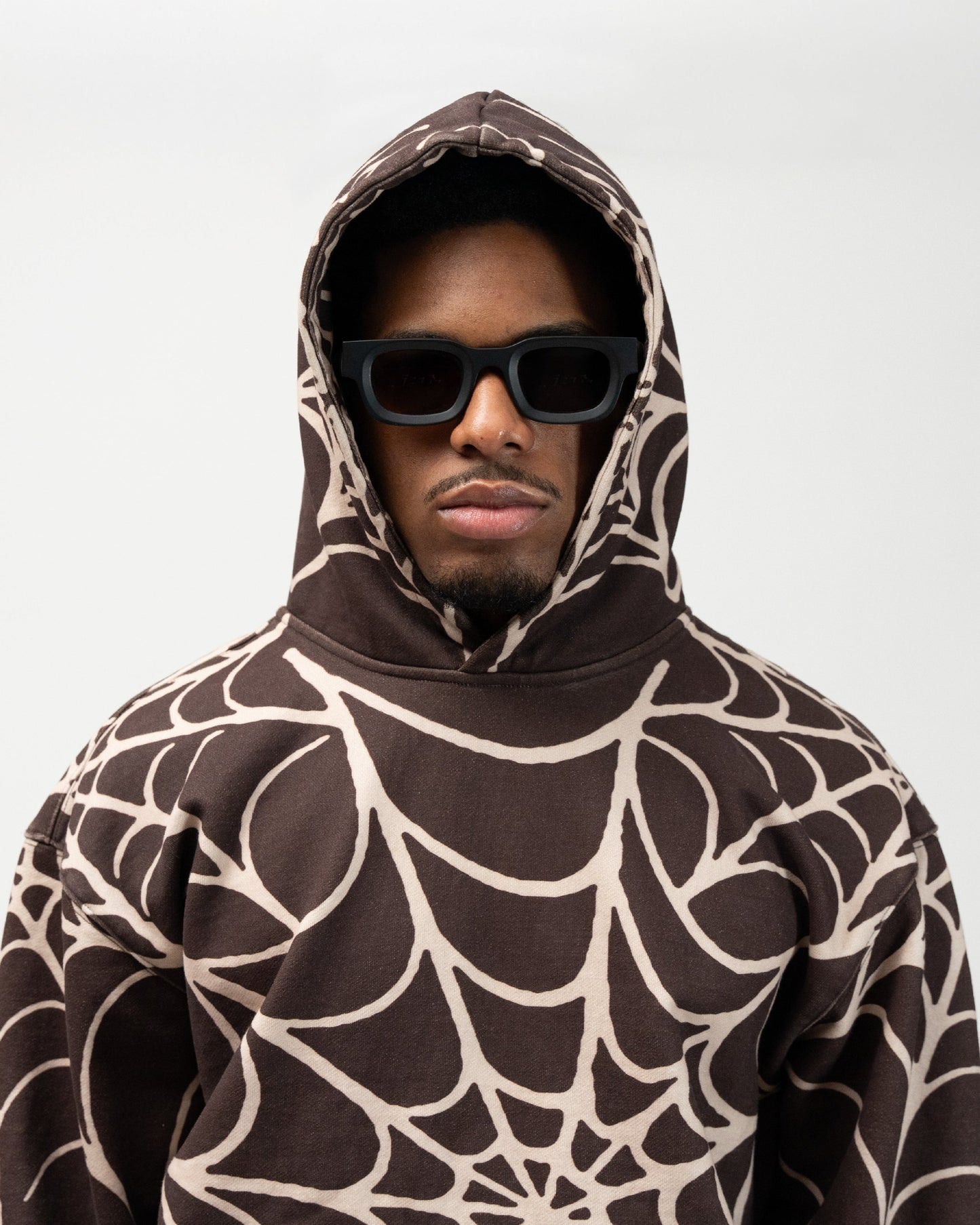 Close up of male model wearing the allover print spider web hoodie. j3t apparel