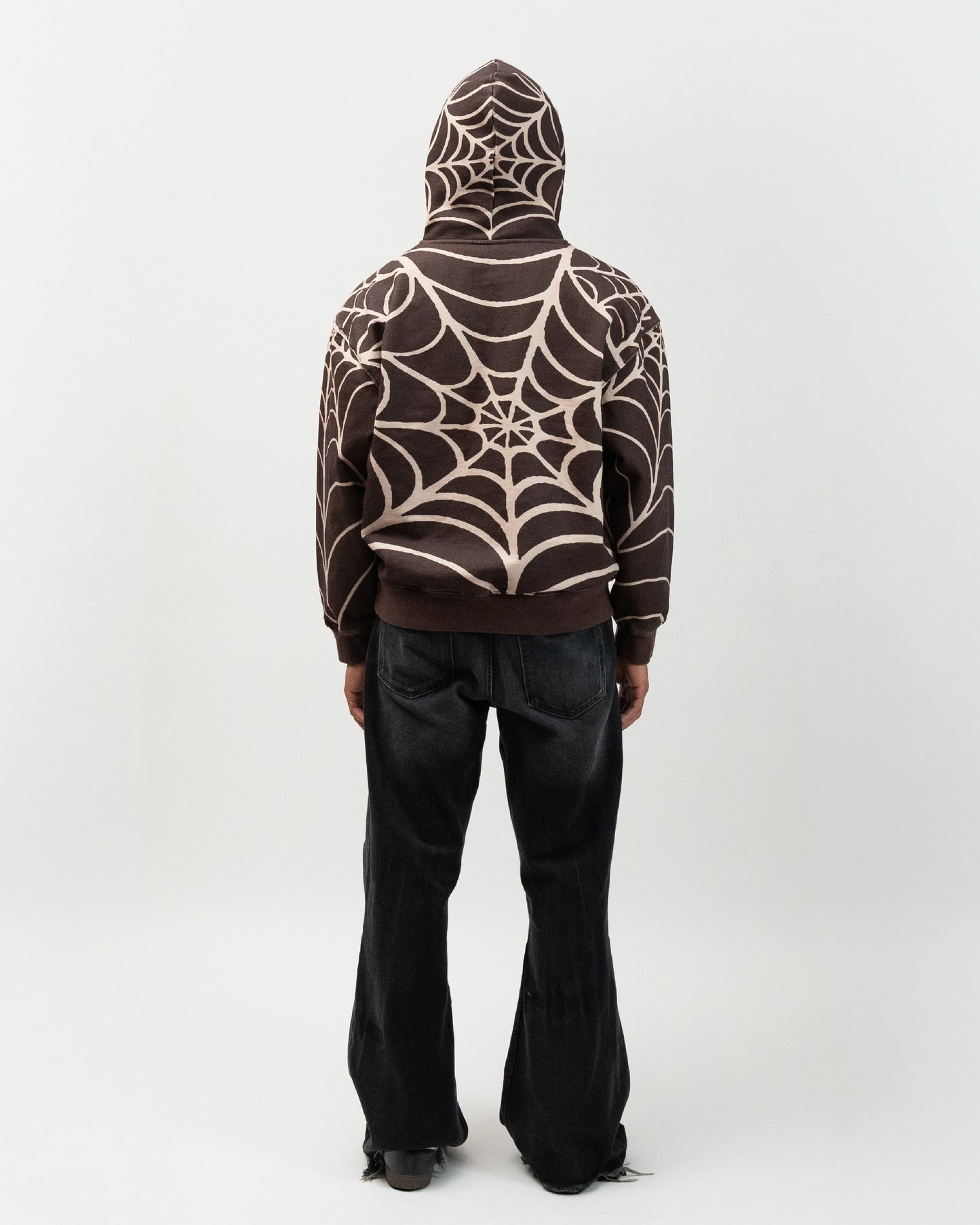 male model wearing the brown spider hoodie with his back turned against the camera. J3T APPAREL