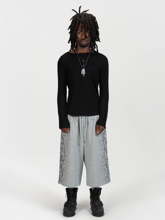 Front facing full body shot of a male model wearing the jafari shrorts by J3T. HE has on a black, long sleeve knit top , and black boots to complete the fit.