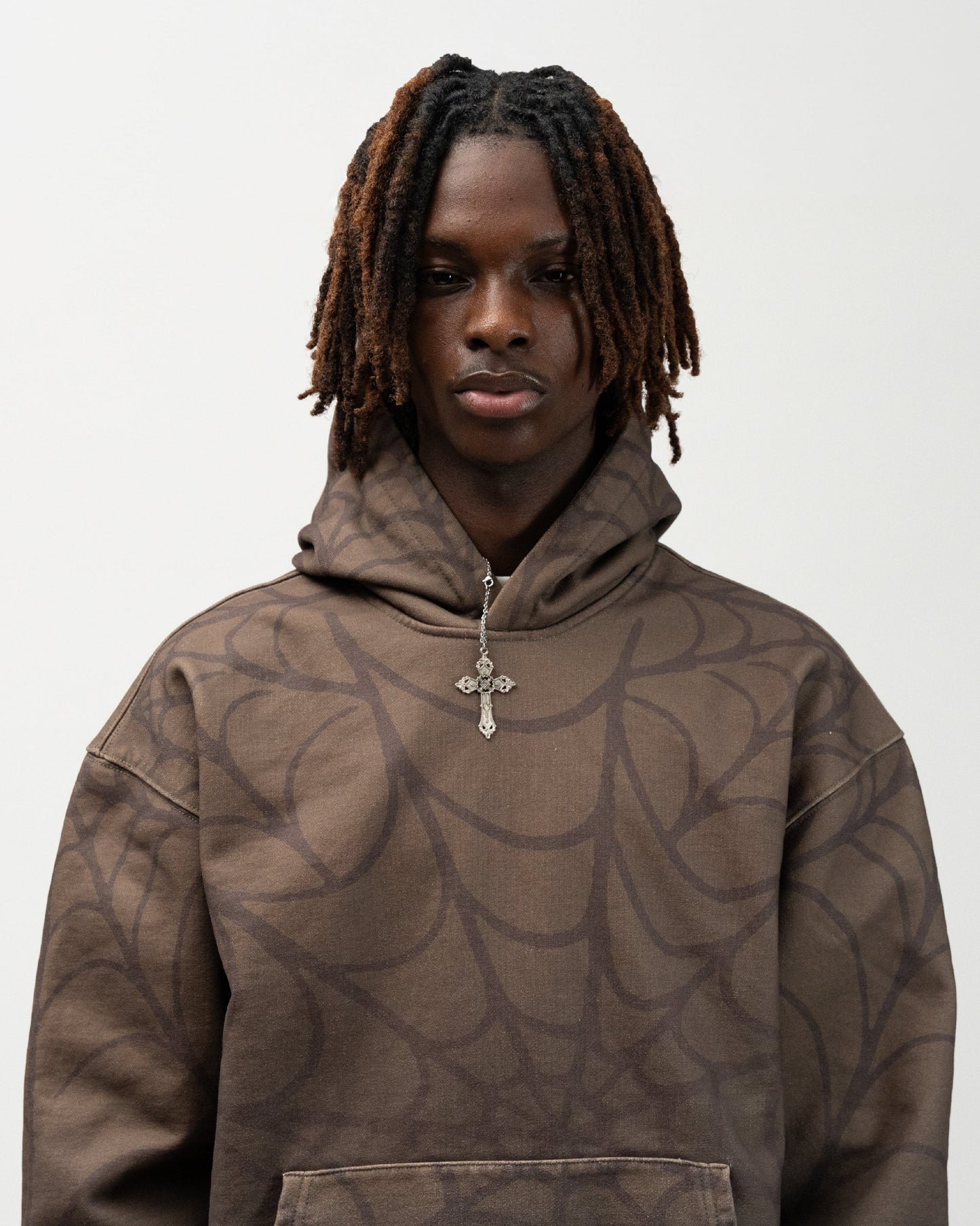 Close up angle of male model wearing the olive green spider hoodie by j3t. everythingj3t