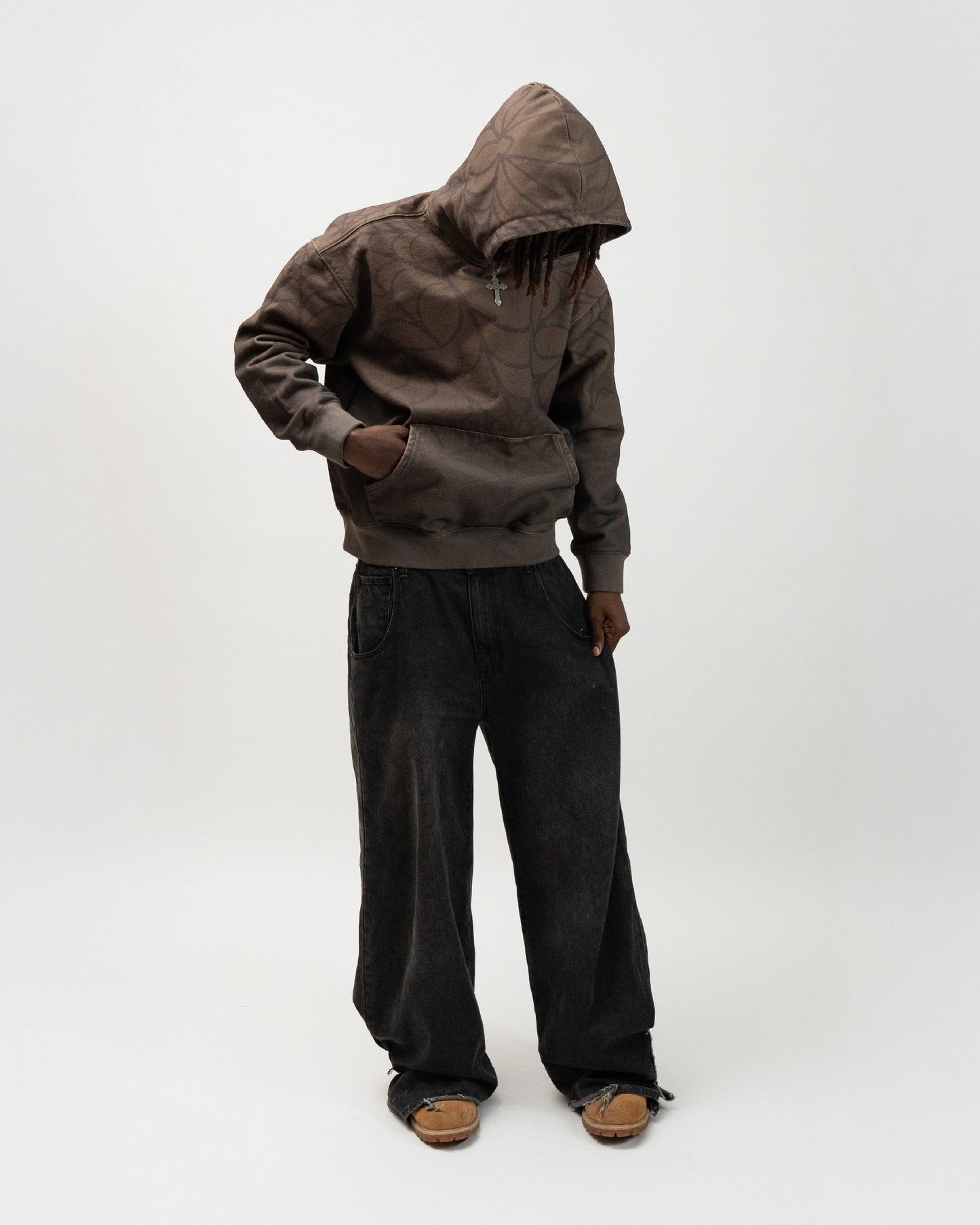 Full body angle of the model posing. He has his right hand in the hoodie pocket and his left hand pulling on the left side of his pants. j3t spider hoodie