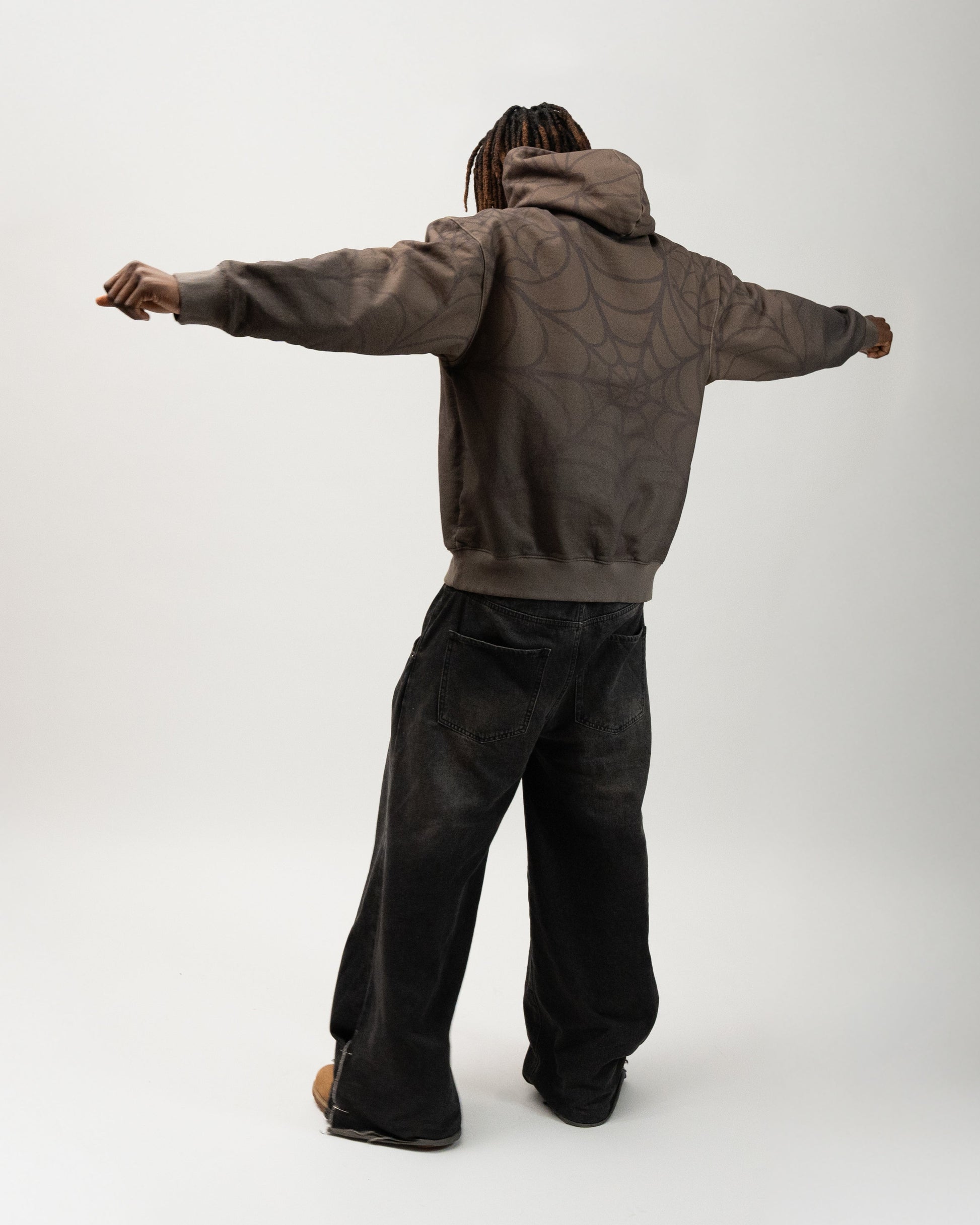 Full body angle of the model posing. his arms are spread out and in a T-pose. you can see the print of the sleeves and back. J3T