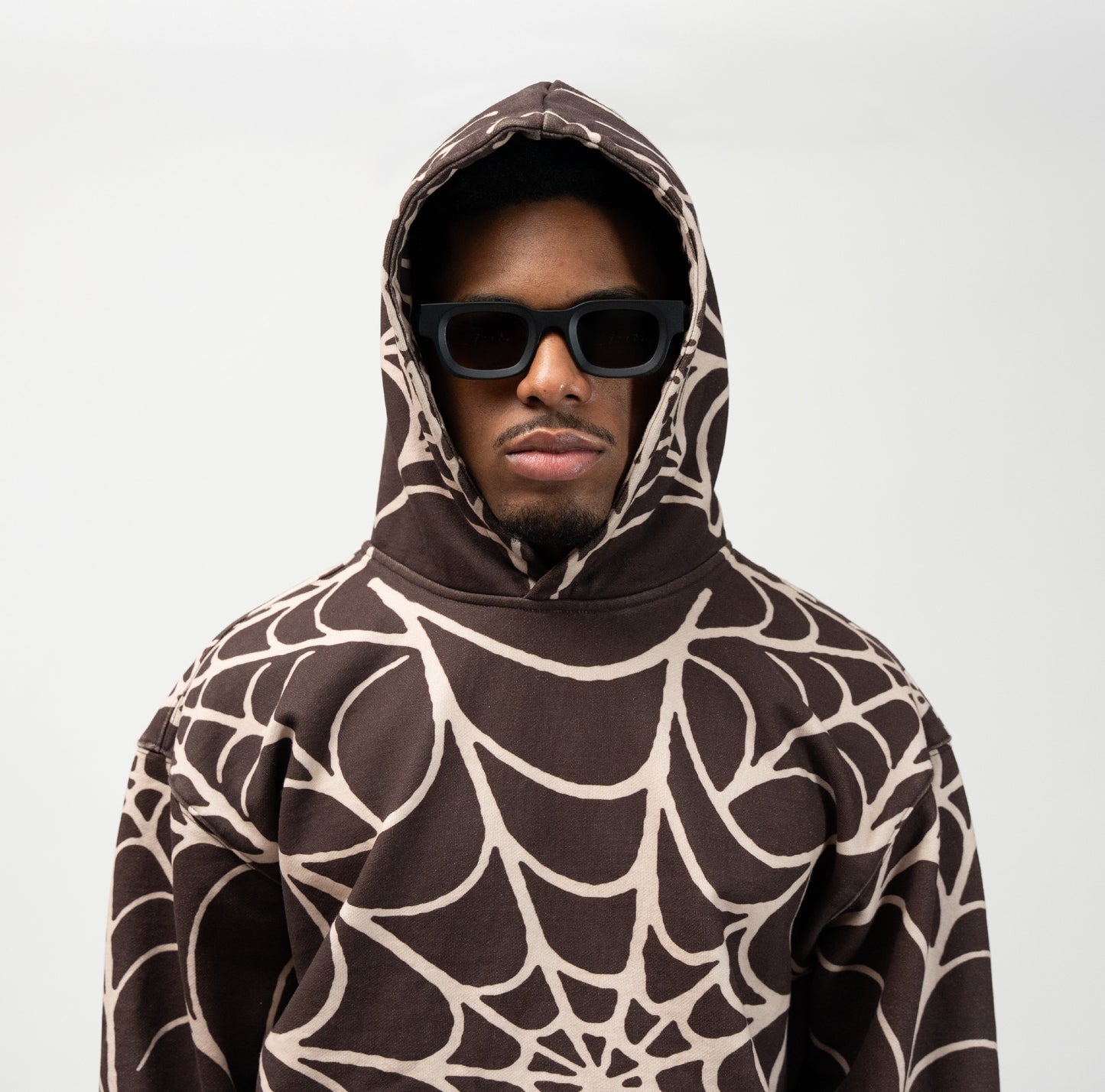 Close up of male model wearing the allover print spider web hoodie. j3t apparel