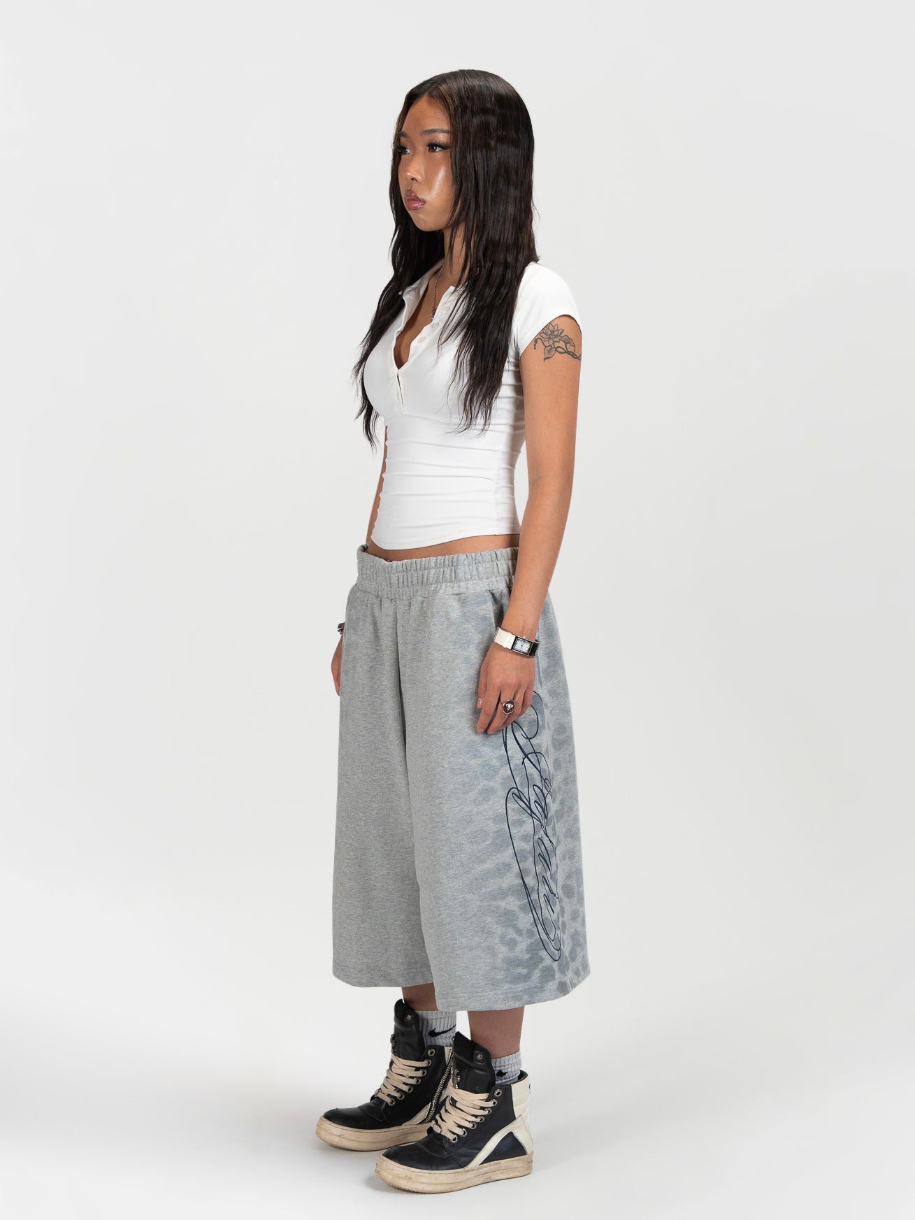 Front side 45 degree facing full body shot of a female model wearing the jafari shrorts by J3T. She has on a white t-shirt, and black boots to complete the fit.. everythingj3t