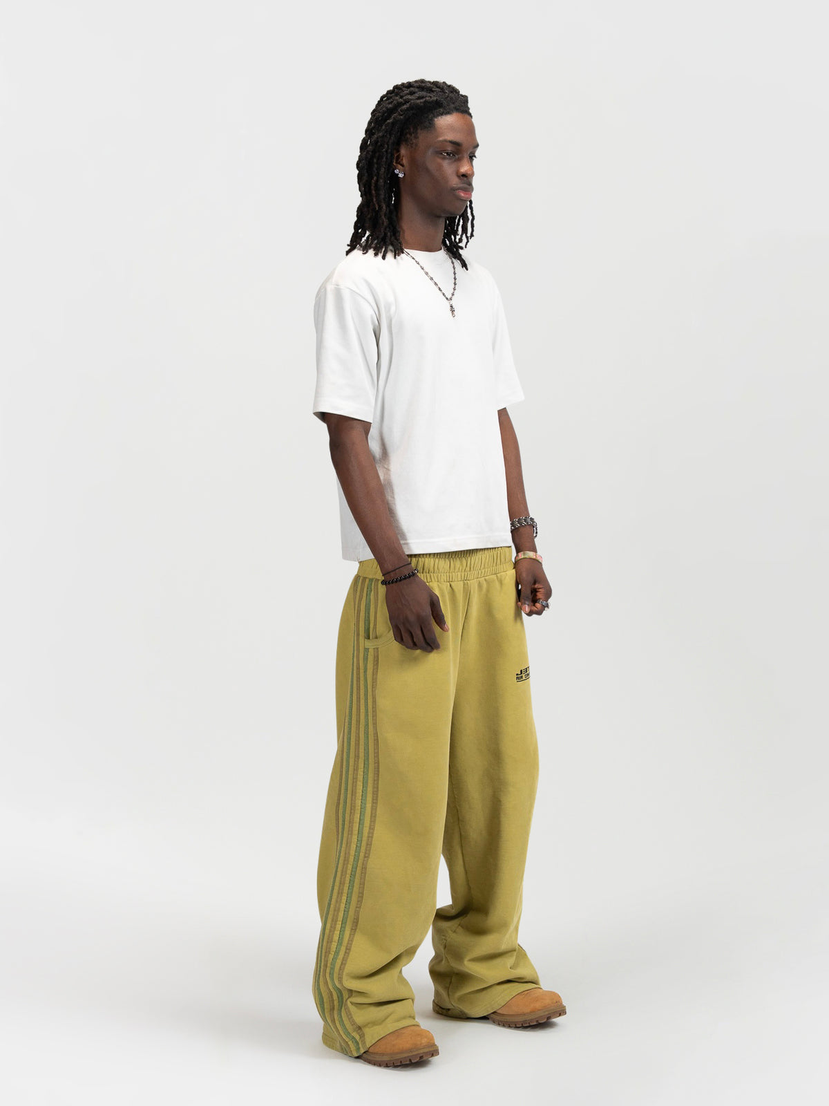right 45 degree facing male model shot of the model wearing the matcha sweats by J3T. He has on a white shirt to complete the fit