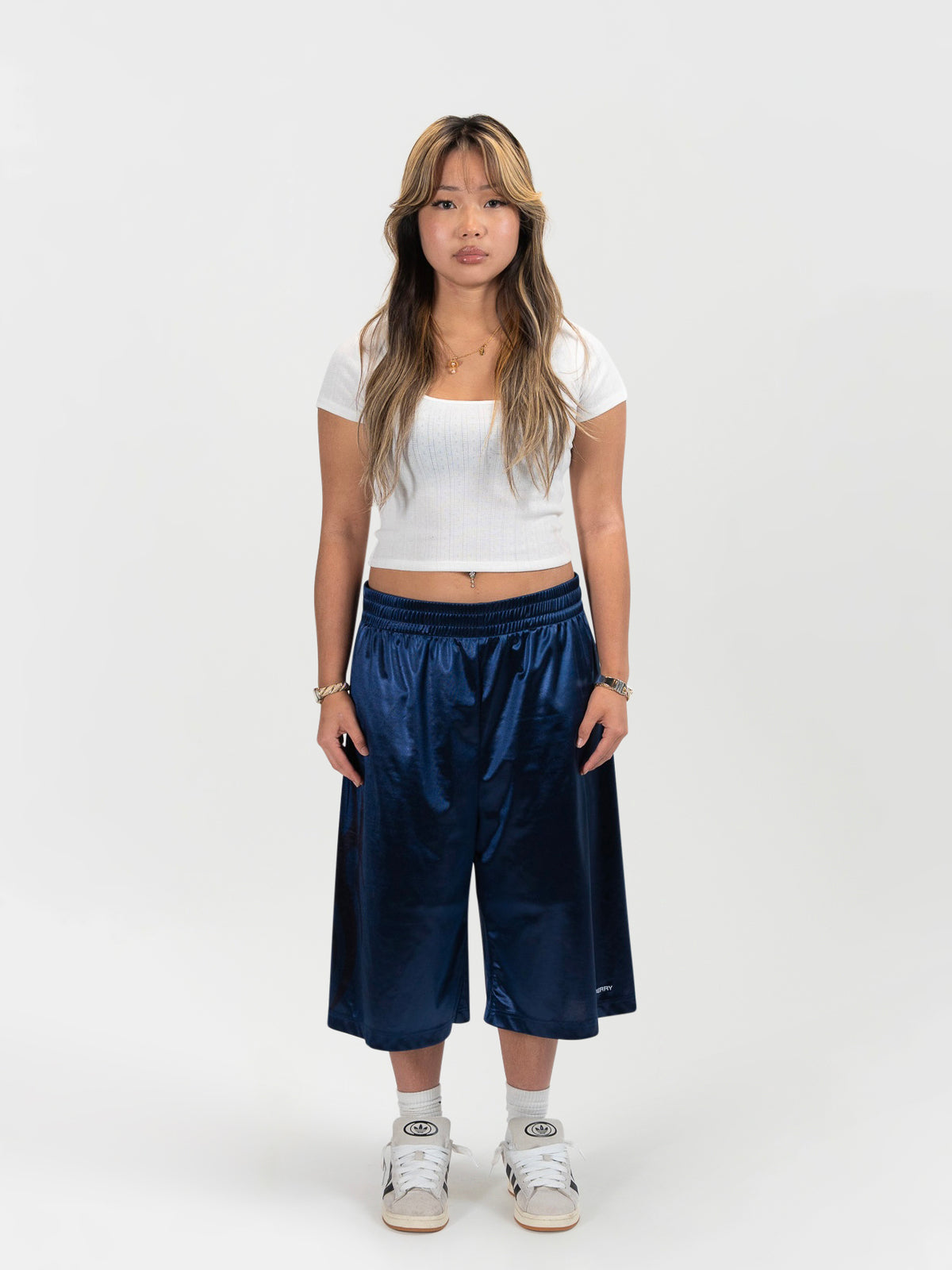 Front facing full body shot of a female model wearing the Tyson shrorts by J3T. She has on a white shirt , and white and cream colored sneakers to complete the fit.