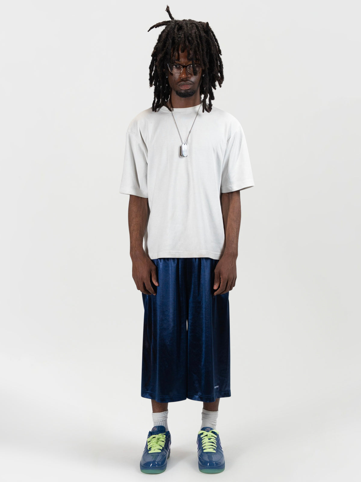 Front facing full body shot of a male model wearing the Tyson shrorts by J3T. HE has on a white shirt , and blue and yellow sneakers to complete the fit.