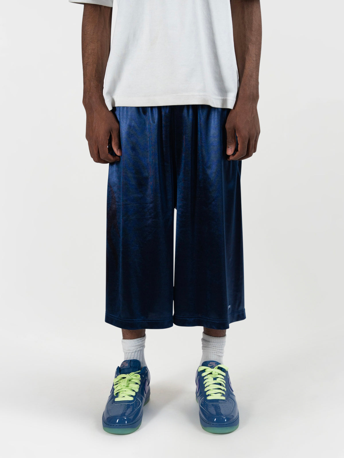 close up front angke of the tyson shorts by j3t. The model's hand is down by the pockets. He has on blue and green sneakers to complete the fit. J3T