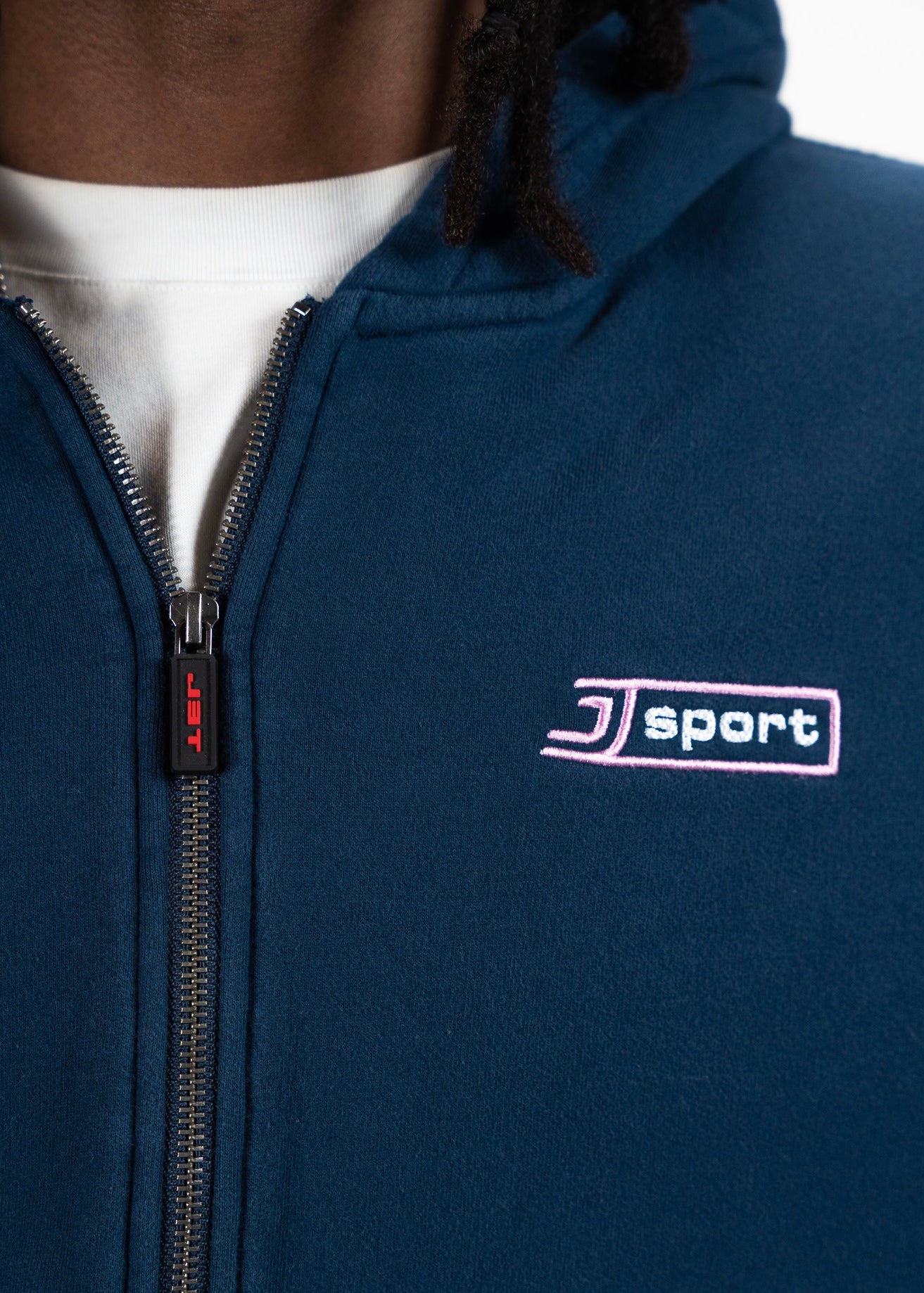 Close-up of the j sport zip. shocasing the embroidery and zipper pull at a close up angle. j3t apparel