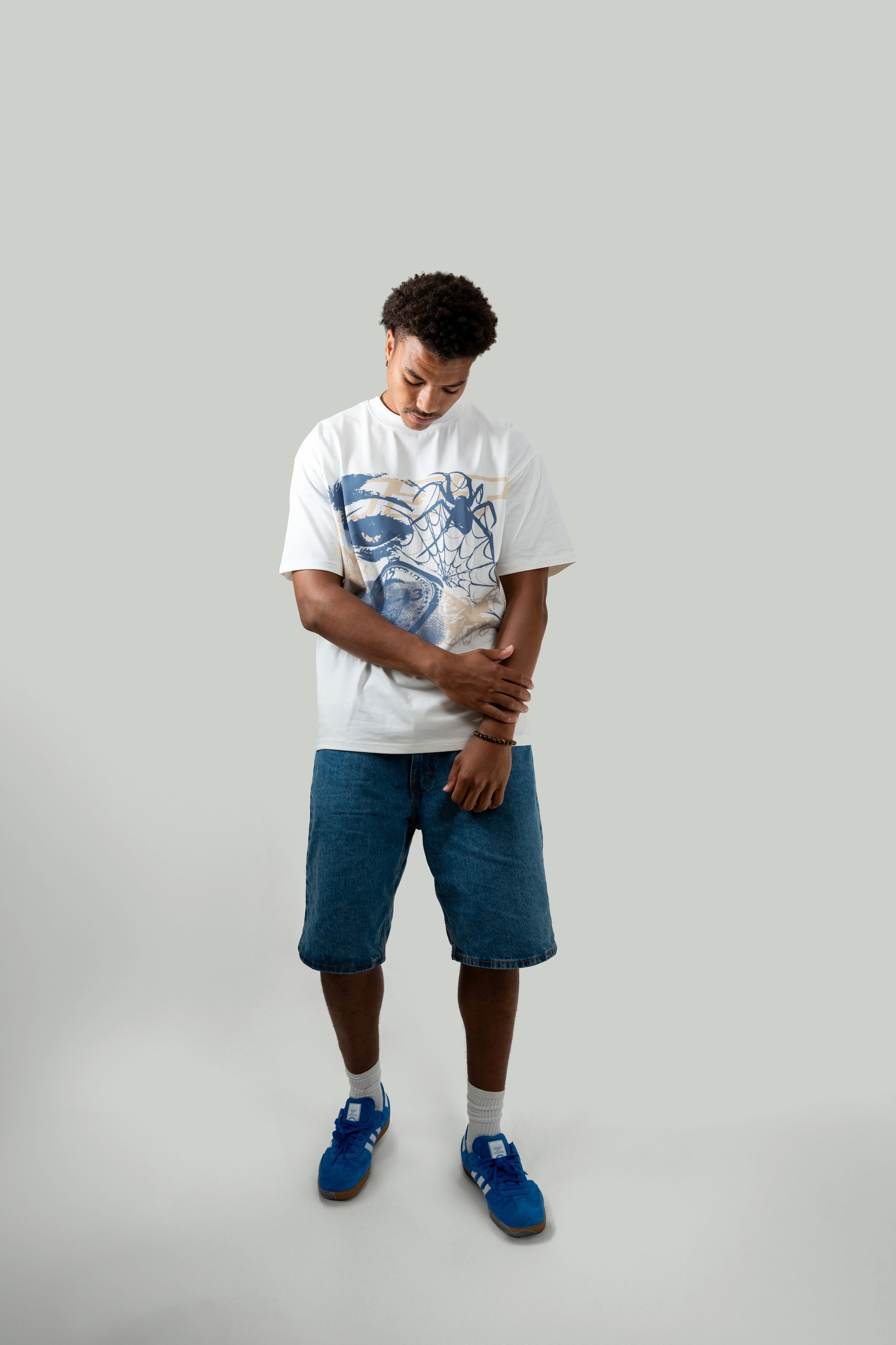 male model looking down posing wearing white flock tee