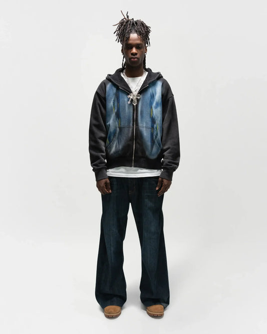 Black male model wearing the dogfight zip up by j3t. This is a full body model photo, he has a poker face and arms down by his hips. jet