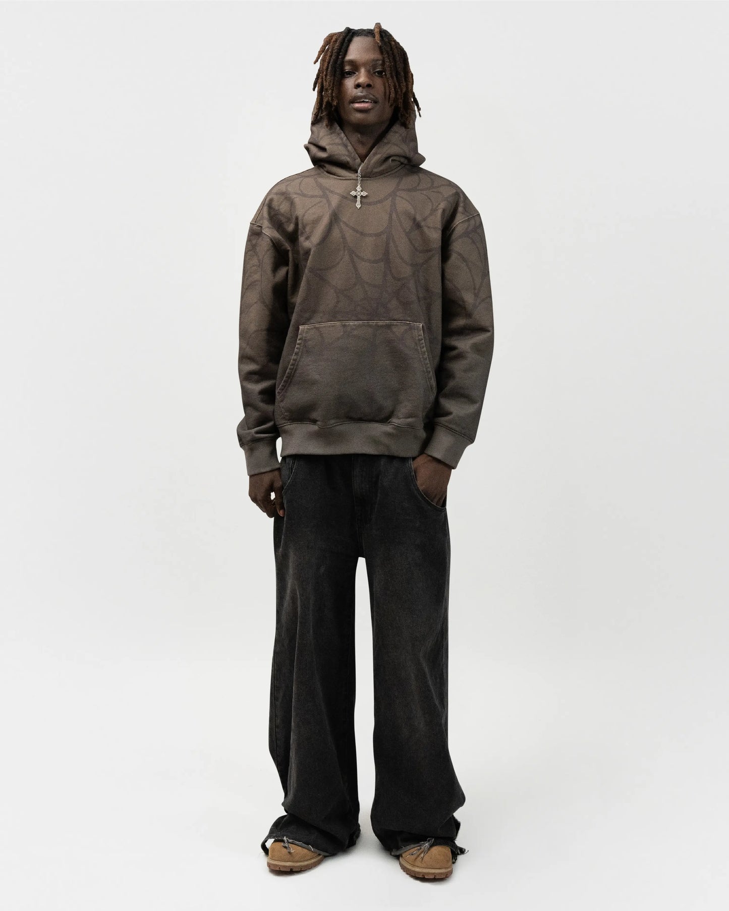 Full body angle of male model wearing the green spider hoodie by j3t. His right hand is in the pocket of his pants. j3t apparel