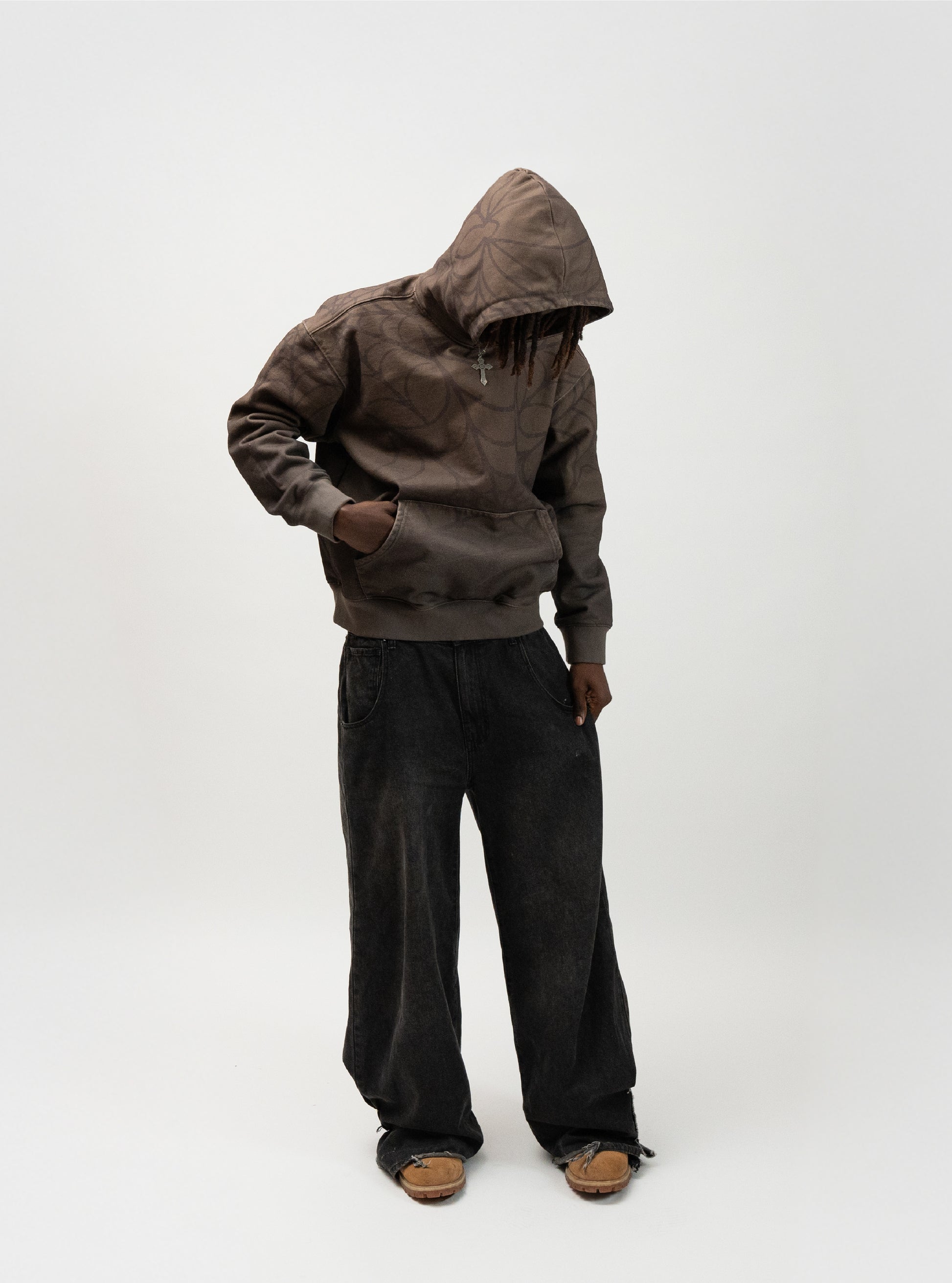 Full body angle of the model posing. He has his right hand in the hoodie pocket and his left hand pulling on the left side of his pants. j3t spider hoodie