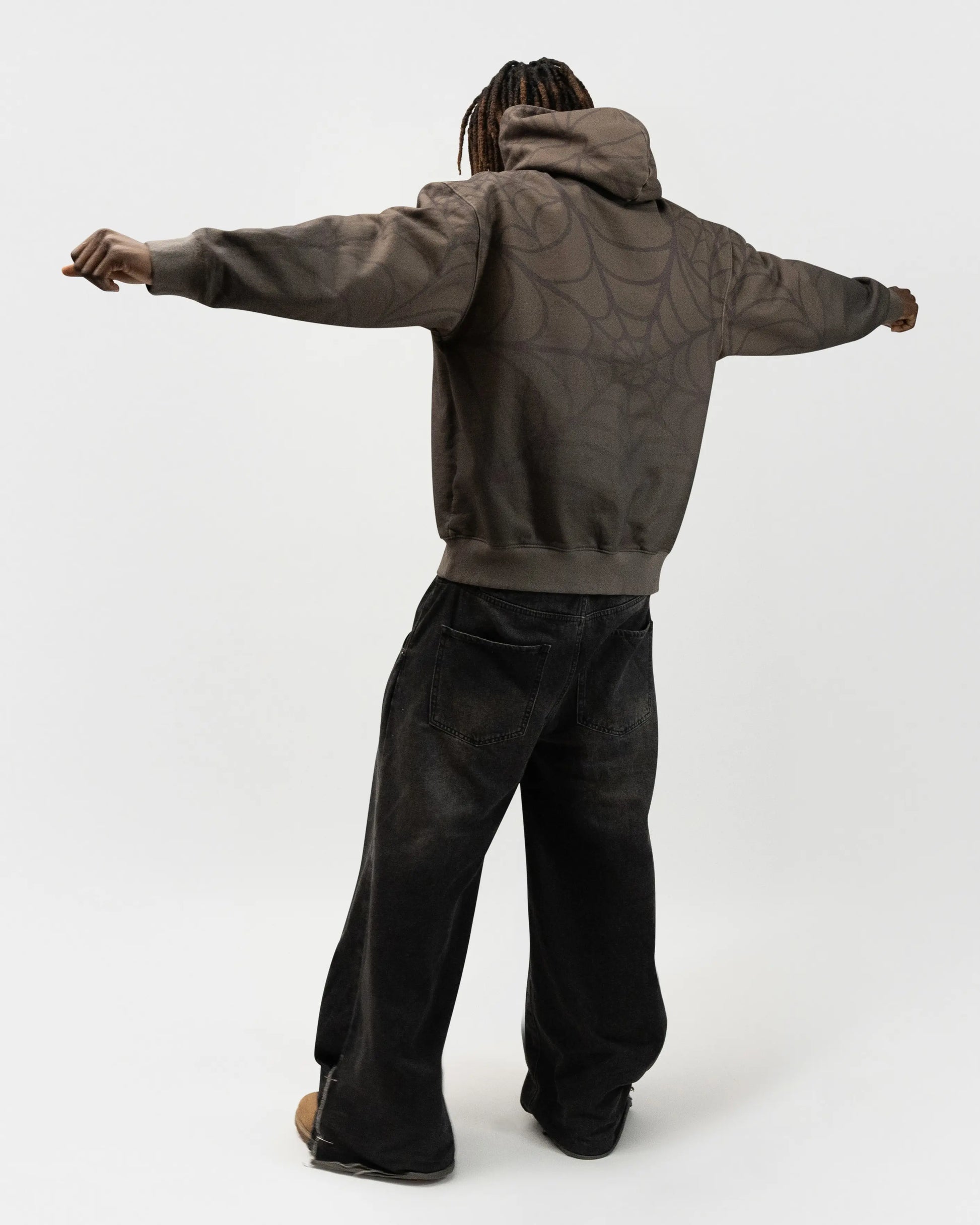 Full body back angle of the model posing. His arms are spread out in a T-pose. spider hoodie by j3t