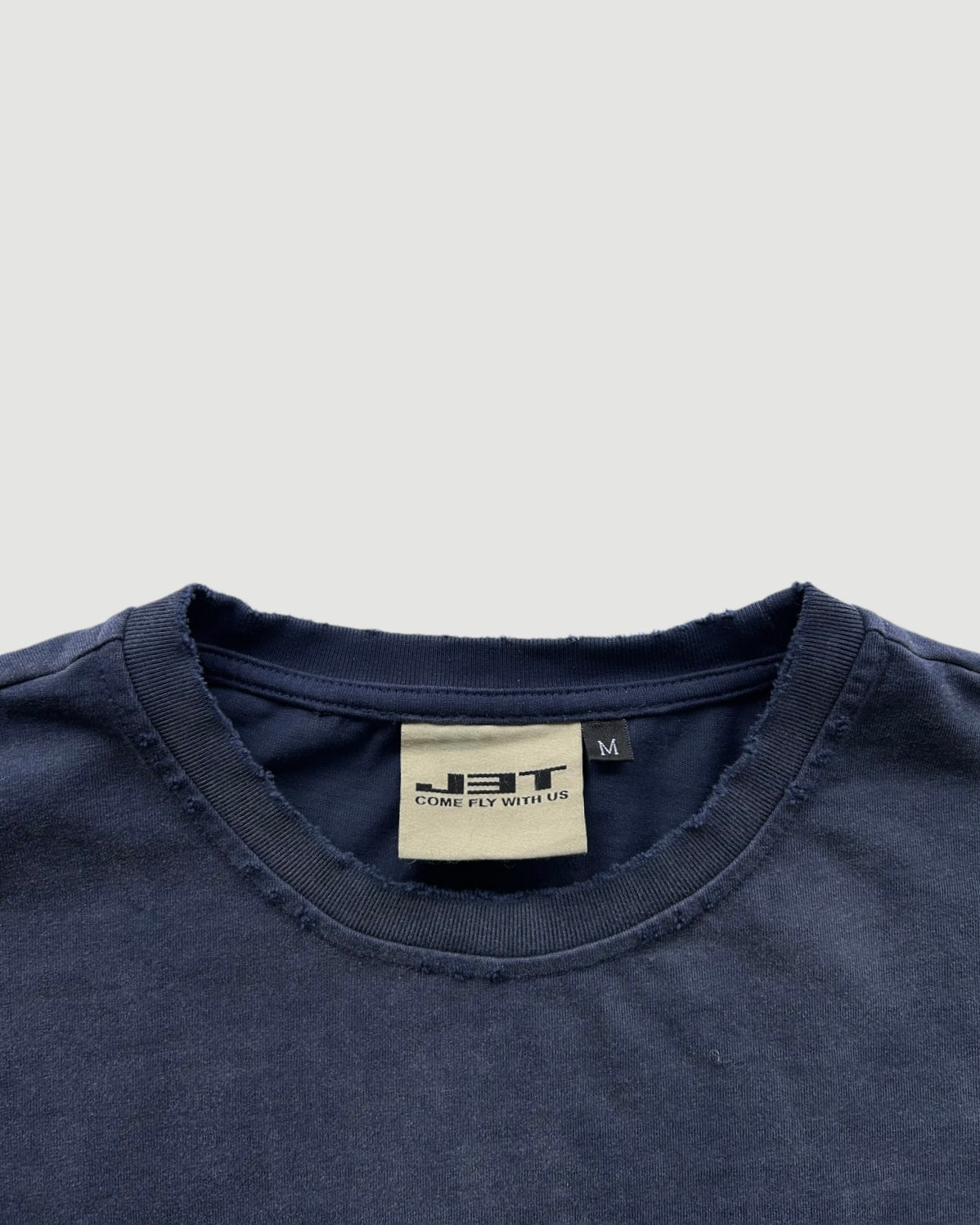 close up collar angle of the air camp tee. showcasing the distressing on the collar. everythingj3t