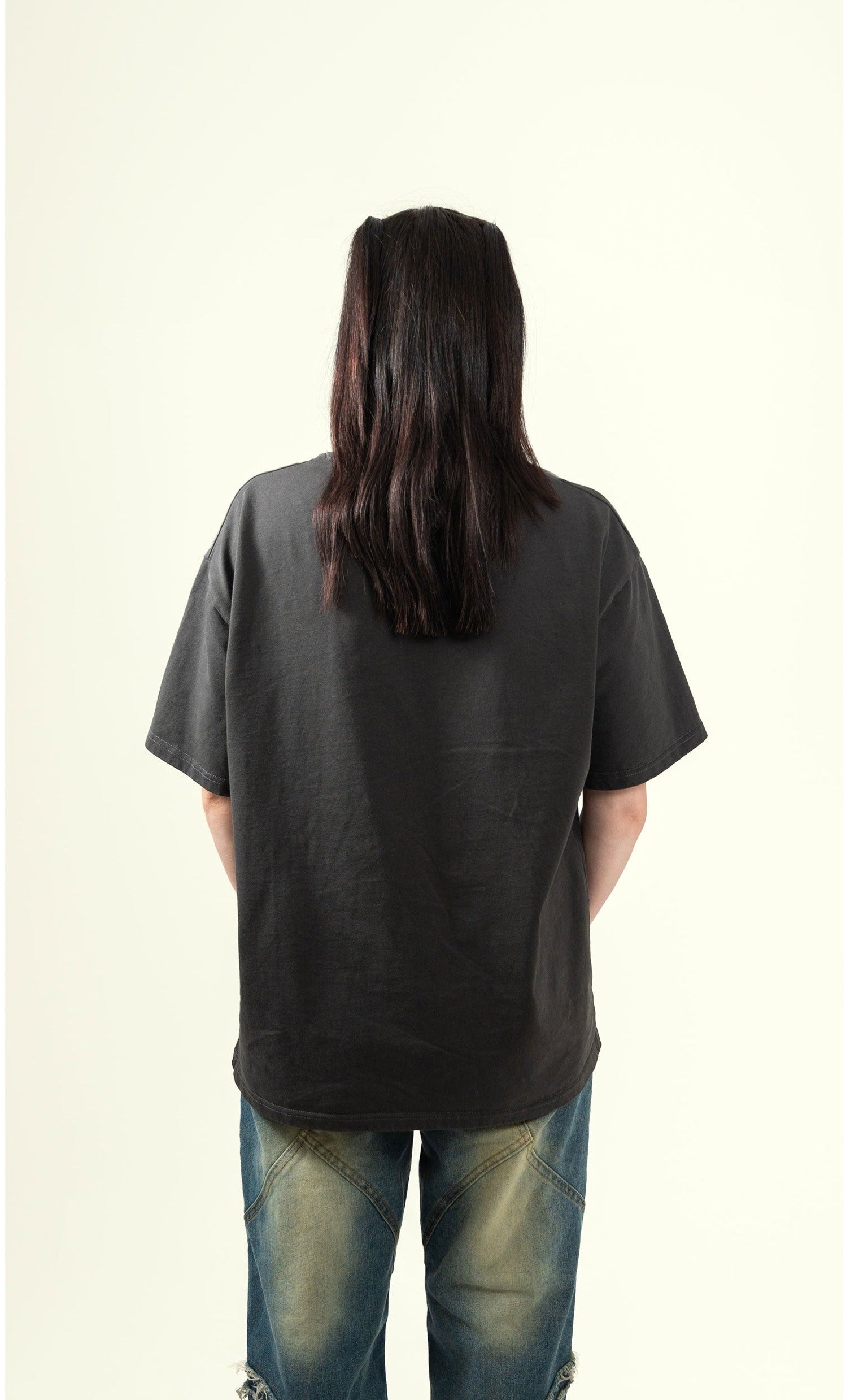 Back view of female model wearing grey flock tee