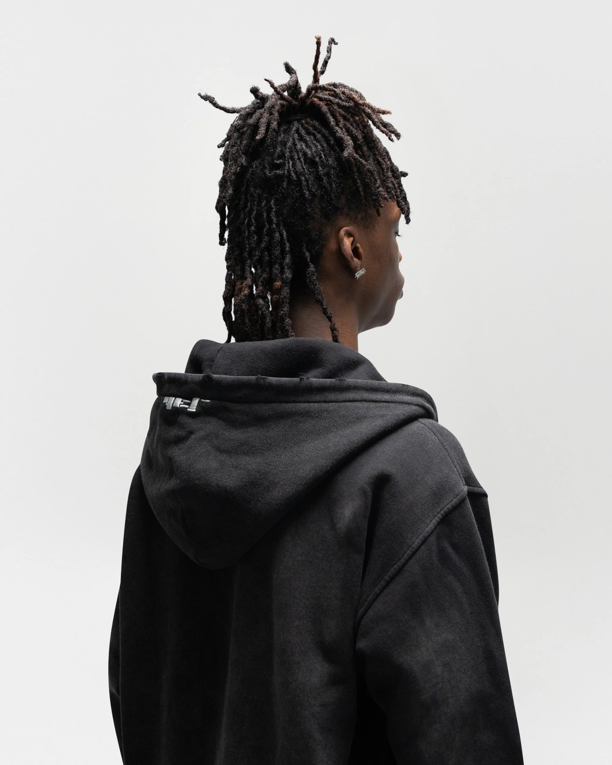 Same model wearing the dogfight zip up by j3t apparel. this is a half body shot of the back. showcasing distressed detailing on the edges of the hood