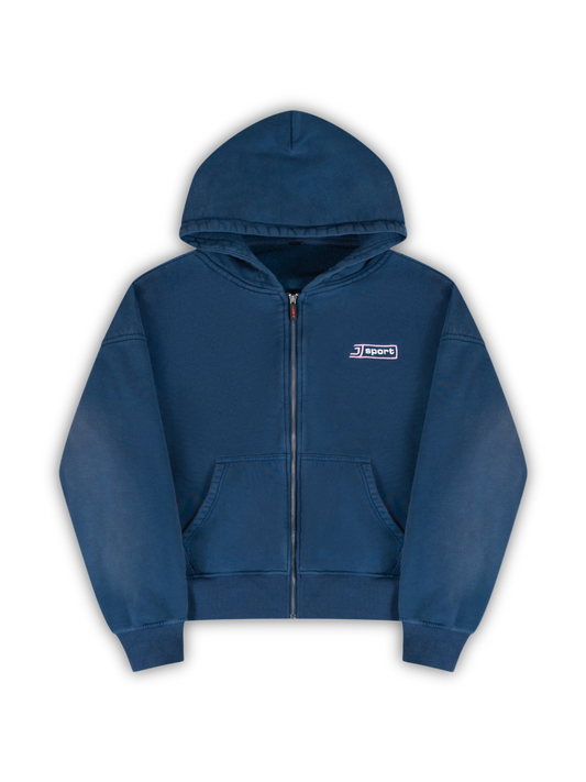 Flat lay picture of the J Sport zip: A navy zip-up hoodie with a small white and pink 'J Sports' embroidery logo on the left chest. j3t