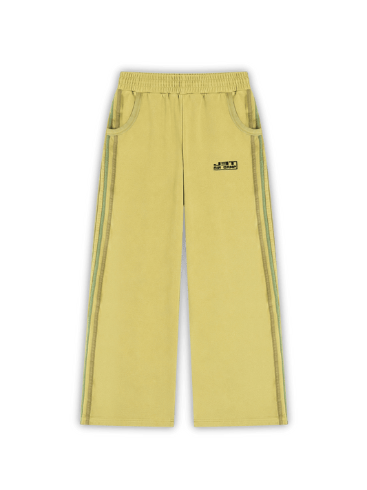 Flat lay photo of the matcha sweats. A wide-leg sweatpants in pale yellow, featuring a black logo embroidery, ribbed side pockets, and 5 side stripes running down the side of the legs on both side. j3t