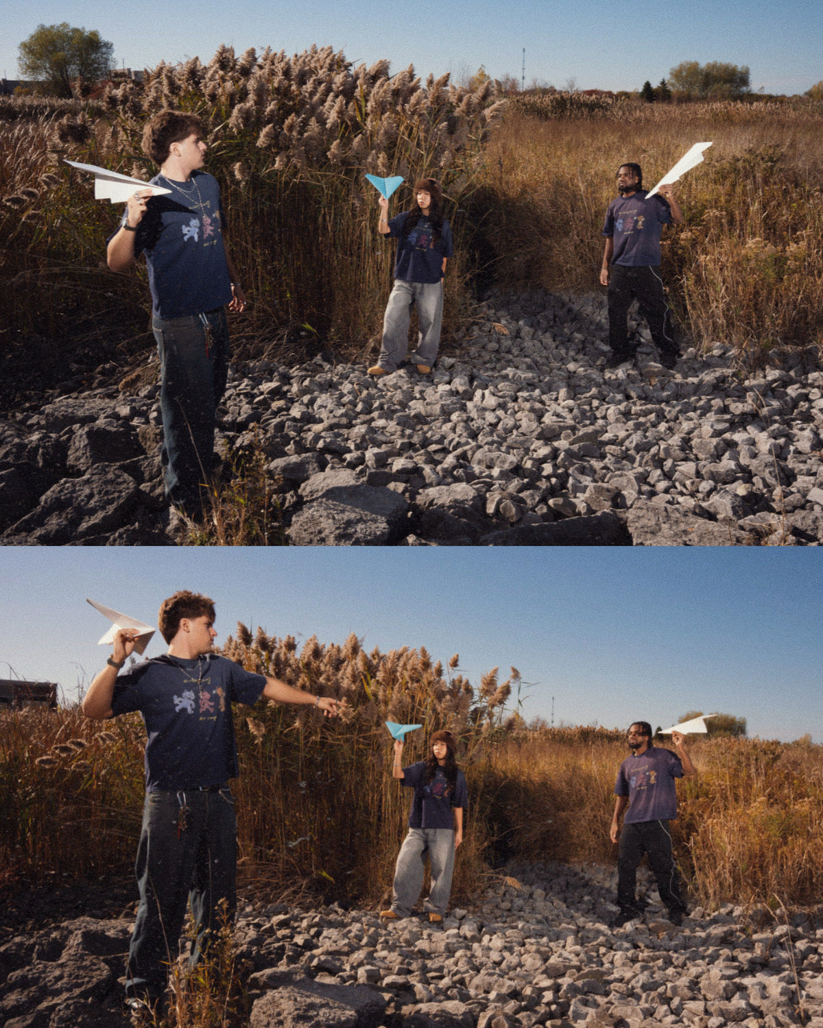 Three people standing outdoors on a rocky field of dry grass, each holding a paper airplane under one arm, with a clear blue sky behind them. creative campaign shot for the air camp tee